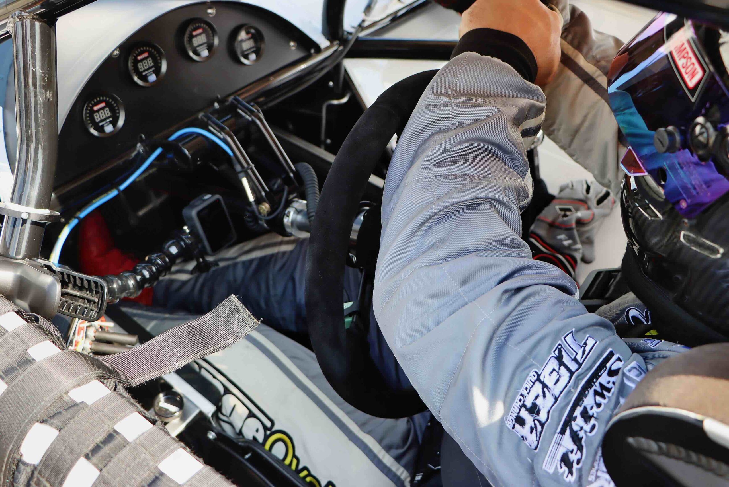 A race car driver uses a steering wheel to control his vehicle.