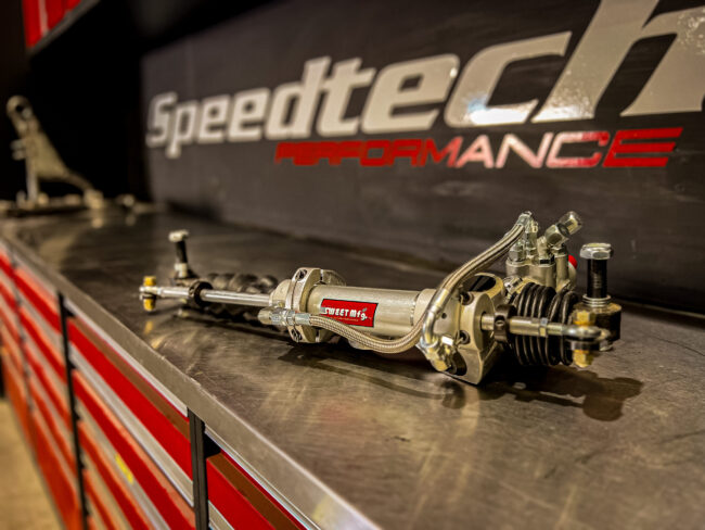 High-performance Sweet Manufacturing power steering rack on a stainless workbench in the Speedtech Performance shop.