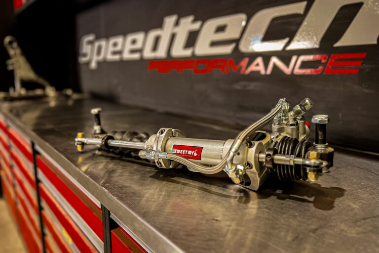 High-performance Sweet Manufacturing power steering rack on a stainless workbench in the Speedtech Performance shop.